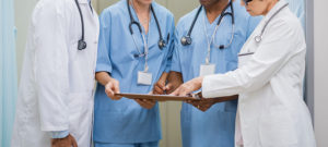 Medical staff making decisions while examing a patient's chart.